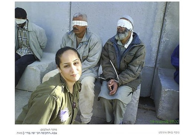 In this undated photo, originally posted on a Facebook page belonging to Eden Aberjil, and taken from the Israeli blog site sachim.tumblr.com, an Israeli army soldier poses in front of blindfolded men identified in the Israeli new media as Palestinian prisoners. Israeli news media and bloggers have identified the soldier in the photos as Aberjil. (AP Photo/sachim.tumblr.com)